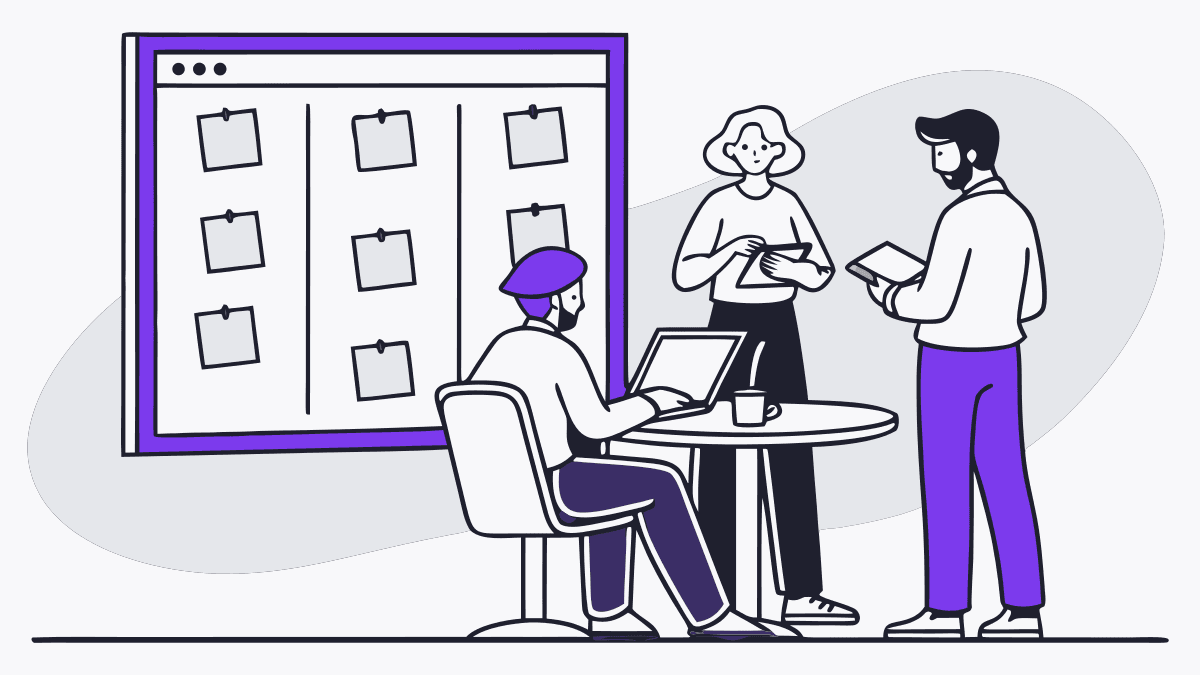 A small team around a table in front of a board of sticky notes